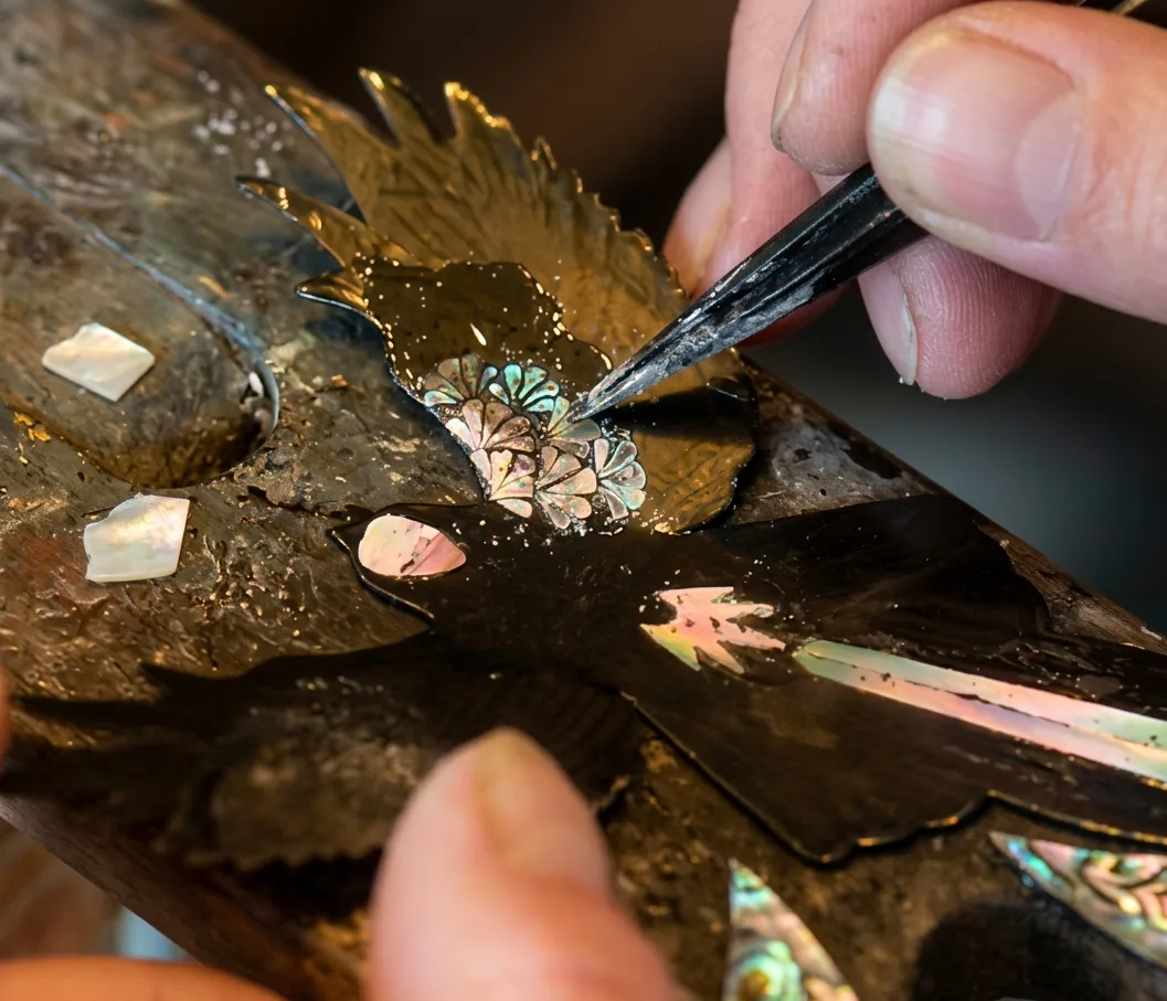 Finished mother-of-pearl inlay work reflecting light with natural iridescence.