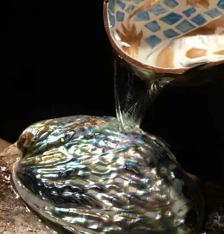 Natural shell fragments displaying vibrant iridescence used for traditional inlay crafts.