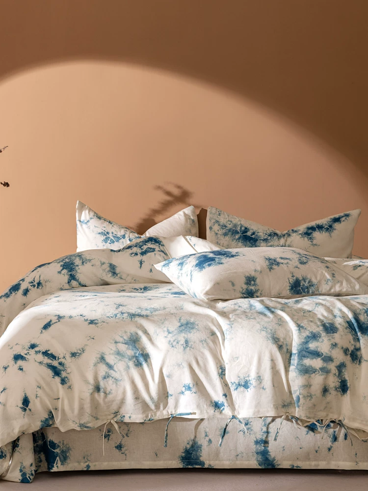 Handmade indigo plant cloud dyeing cotton and linen four-piece set lifestyle display on natural backdrop