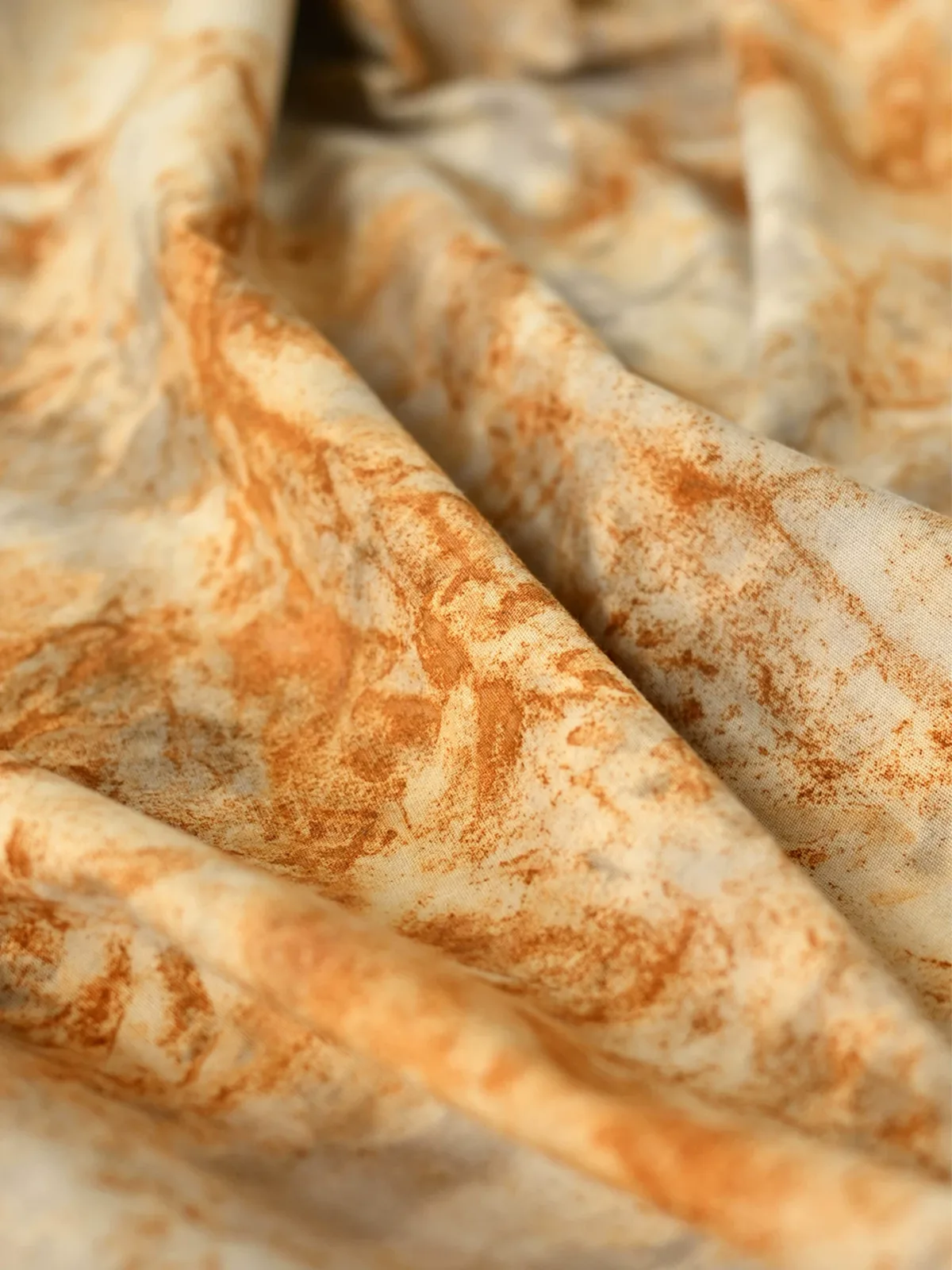 Rust and tea-dyed cotton showing irregular plant-dyed patterning