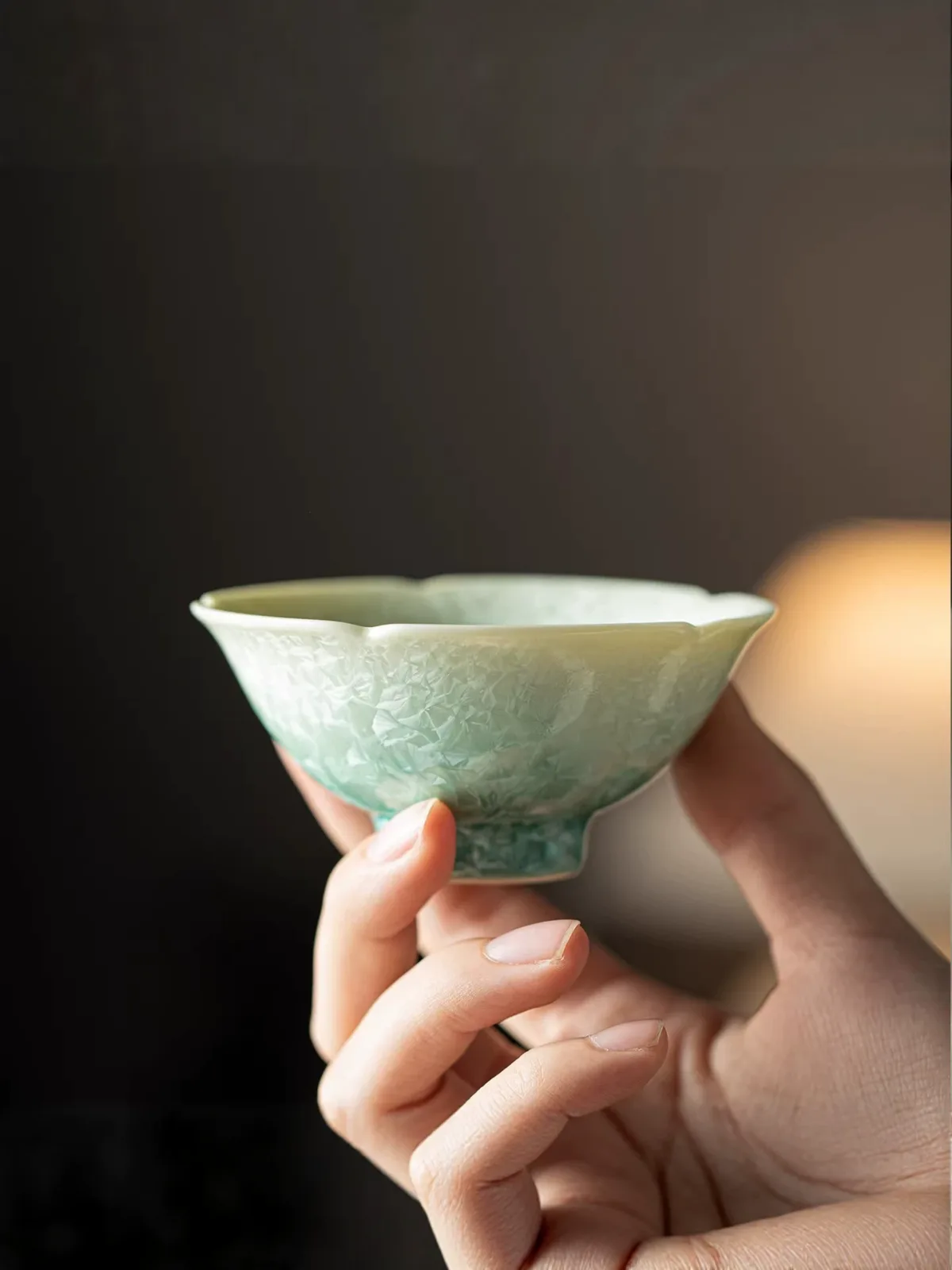 Green crystalline glaze teacup photographed from a second angle